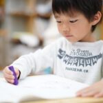 クレヨンで絵を描く少年